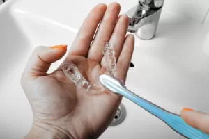 Cleaning mouth guards with toothbrush